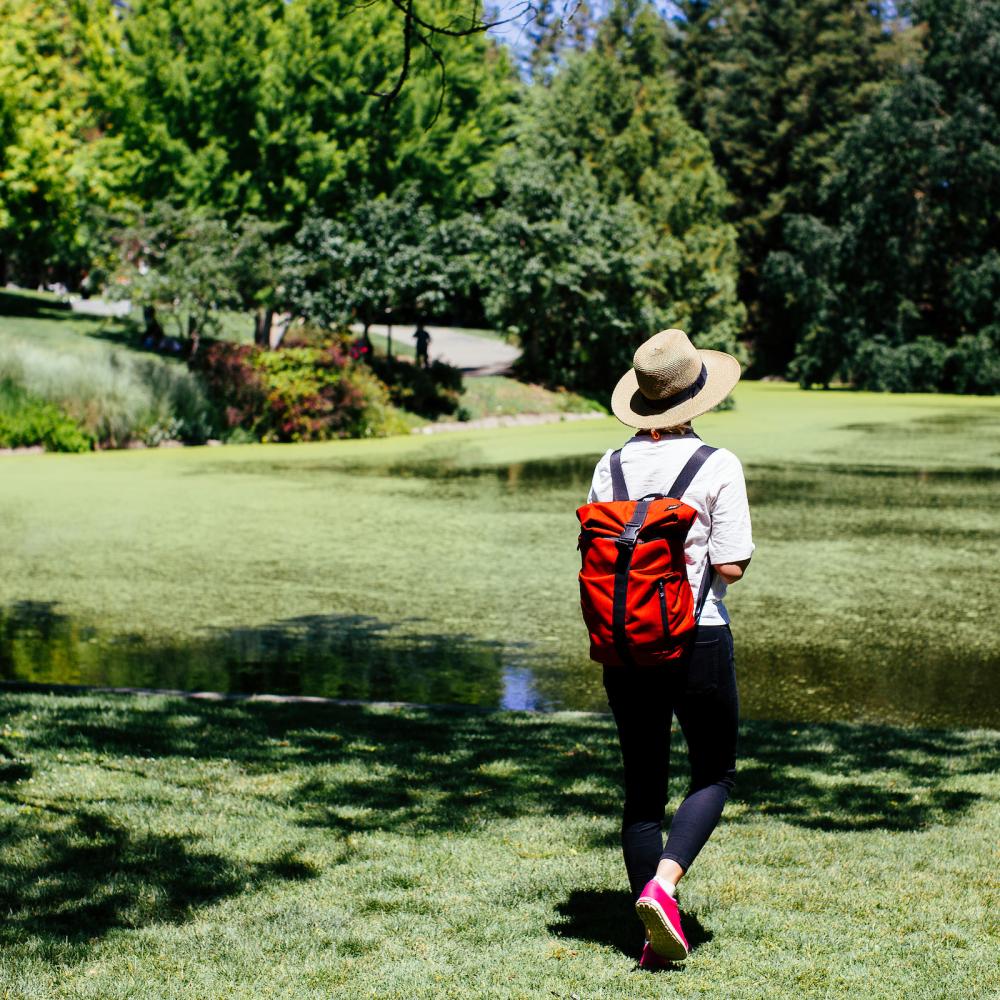 Student with red backpack walking in quad