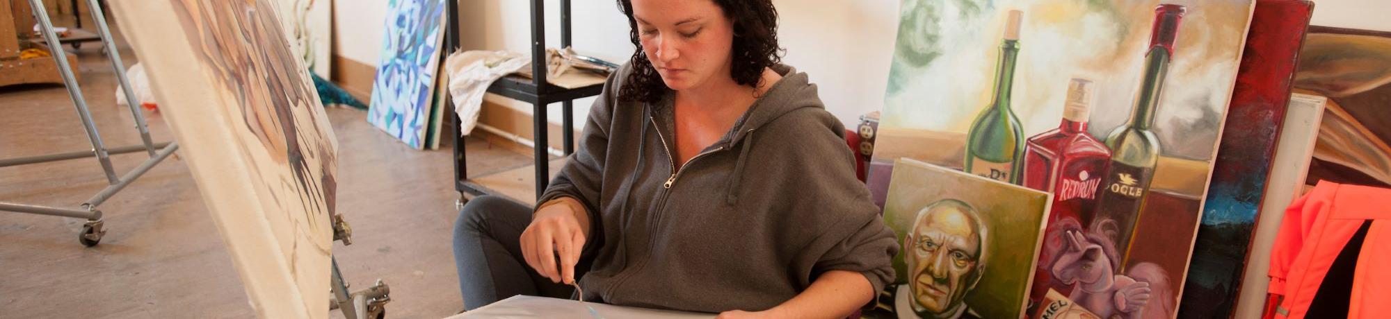 Art student in the painting studio with red backpack